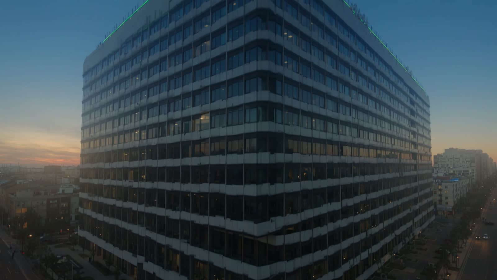 A multi-storey commercial office building at dusk.